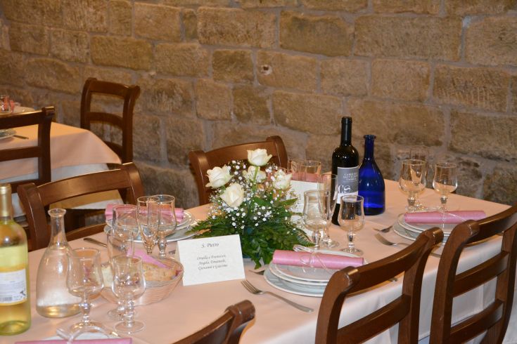 Eine einfache Tischdekoration mit Blumen und Wein in einer warmen und lebhaften Umgebung.