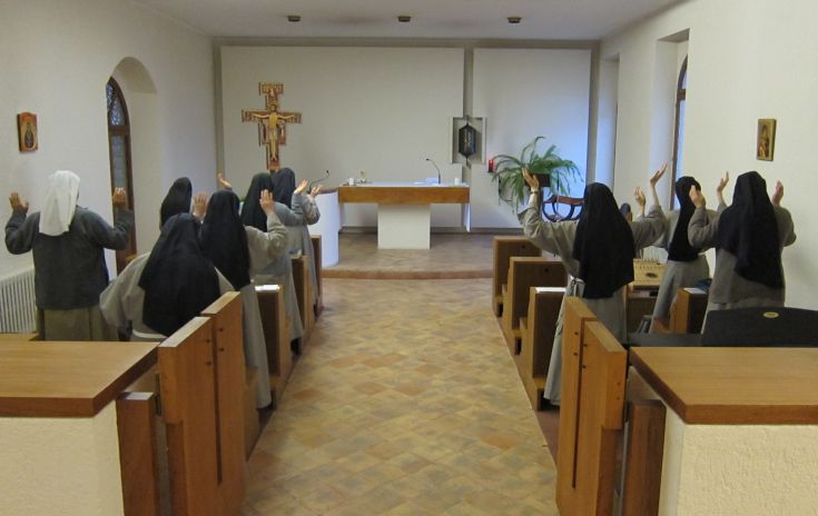 Sorelle Clarisse in preghiera all'interno del monastero di Santa Colette, circondato da un'atmosfera di calma e spiritualità.