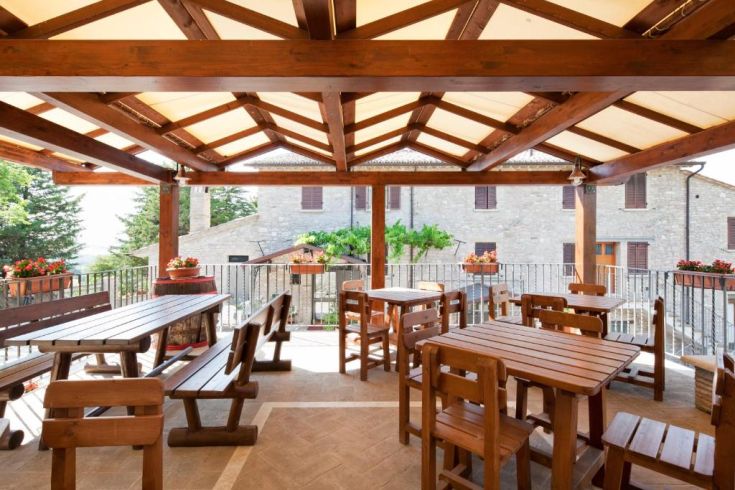 Außenbereich mit Holztischen, ideal zum Genießen lokaler traditioneller Küche.