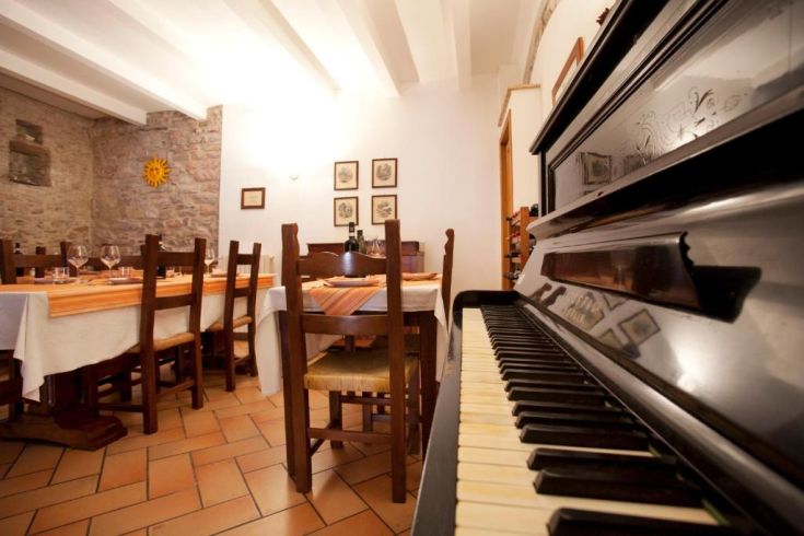 Ein gemütliches Restaurant mit sorgfältig angeordneten Tischen und einem Klavier, das die angenehme Atmosphäre unterstützt.