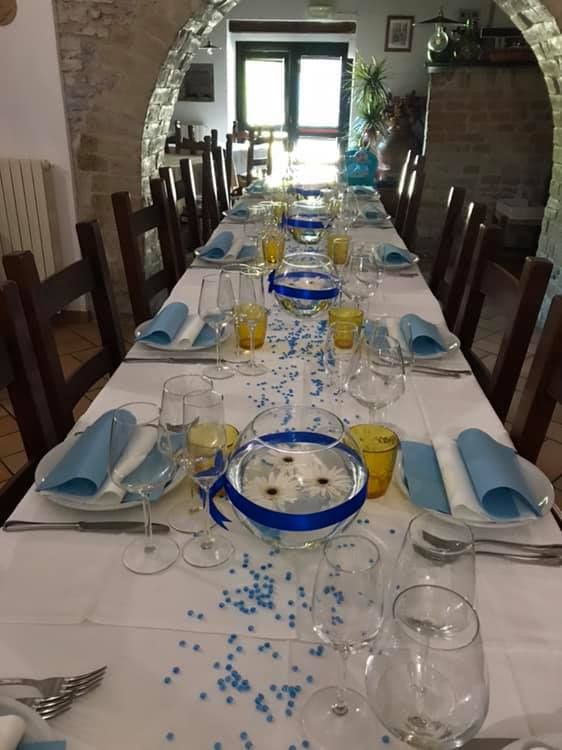 Ein gedeckter Tisch mit blauen Akzenten und einigen Blumen dekorationen, bereit für Gäste.