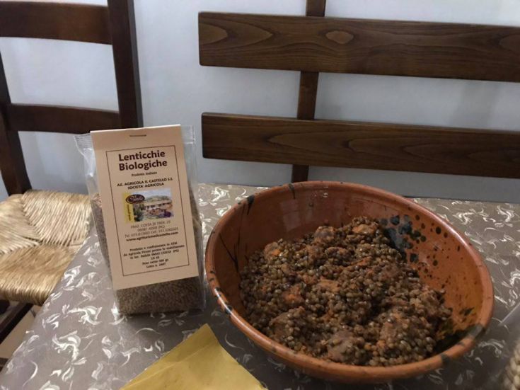 Bio-Linsen in einer Terracottaschüssel, auf einem Tisch in einer einfachen und gemütlichen Umgebung platziert.