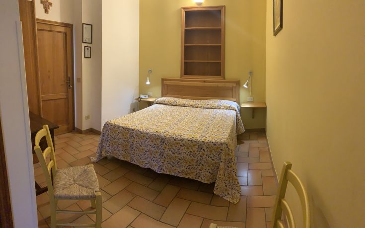 Einfache Zimmer mit einem Doppelbett und Blumendetails. Ideal für einen ruhigen Aufenthalt in einer familiären Umgebung.