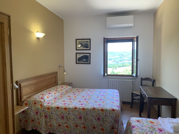 Ein einfaches und komfortables Zimmer mit Blick auf die umliegende Natur, perfekt für Entspannungsmomente.