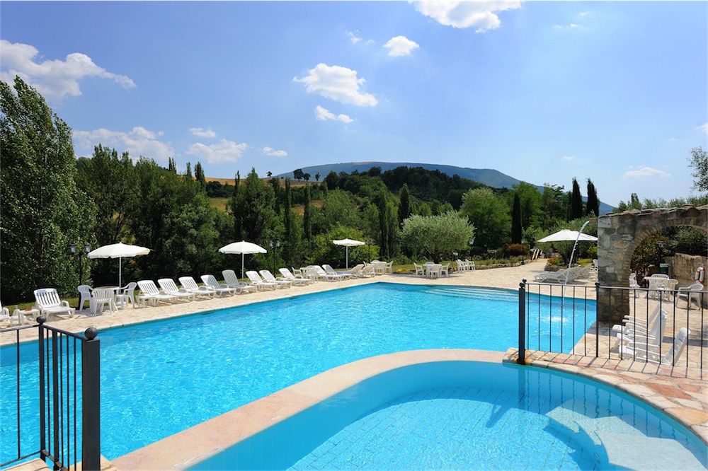 Una piscina tranquilla circondata da verde, perfetta per momenti di relax nella natura.