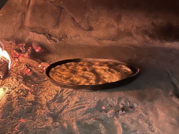 Pane cotto in un forno tradizionale, rappresentando una pratica culinaria tipica della zona.