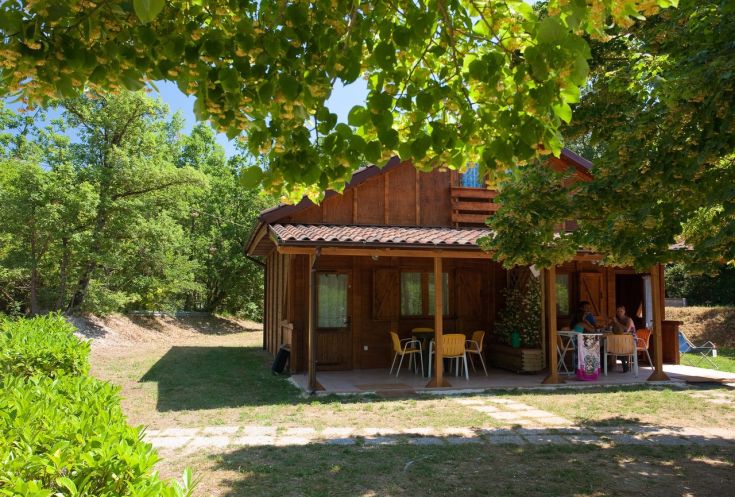 Chalet entouré d'arbres et de verdure, un environnement tranquille pour se détendre dans la nature.