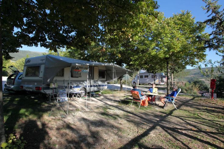 Un camping tranquille dans la nature, entouré par les Monts Sibillini et une verdure luxuriante.