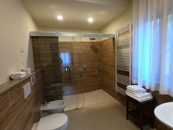 A well-maintained bathroom featuring a glass shower and oak wood details, perfect for relaxing moments.