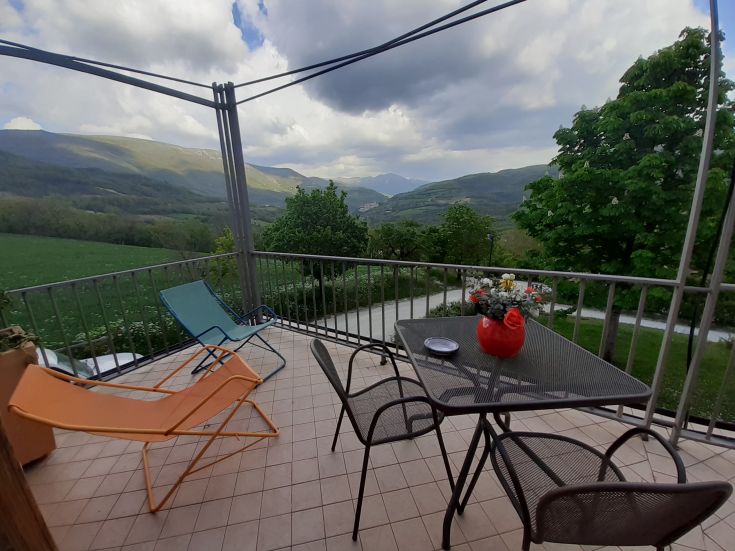 Enjoy the terrace with a stunning view of the mountains, surrounded by lush vegetation.