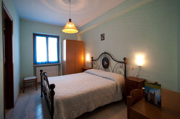 Chambre spacieuse avec un lit double, armoire et commodités essentielles, parfaite pour un séjour relaxant.