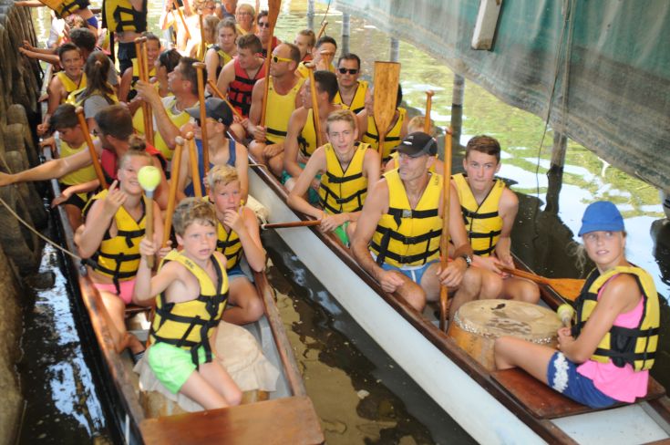 Groups of young people in canoes, ready for an outdoor activity on the lake.