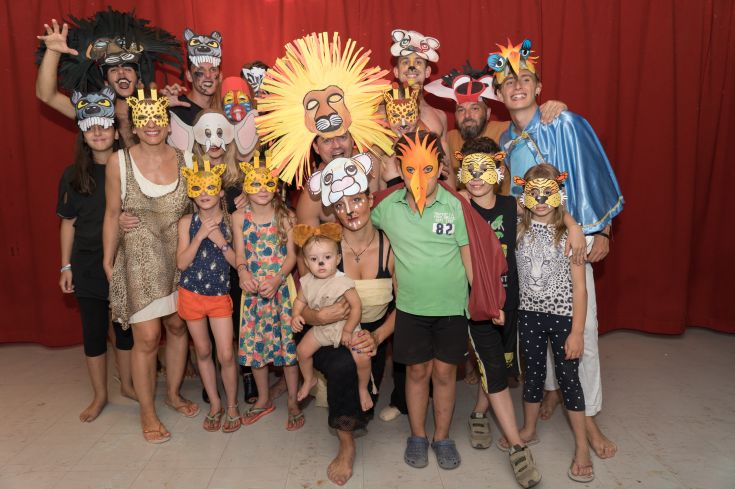 A group of masked individuals enjoying a vibrant costume party, filled with joy and colorful outfits.