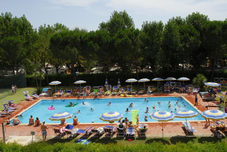 Piscina con ombrelloni e lettini, dove diverse persone si godono un momento di relax e divertimento.