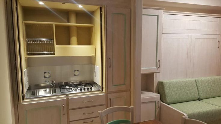 Cucina pratica con lavello e forno a gas, ideale per ambienti di dimensioni contenute.