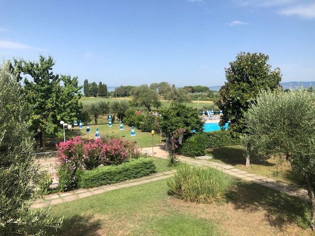 Un angolo di tranquillità nella natura, con il Lago Trasimeno in lontananza. Ampi spazi verdi e piscine a disposizione.