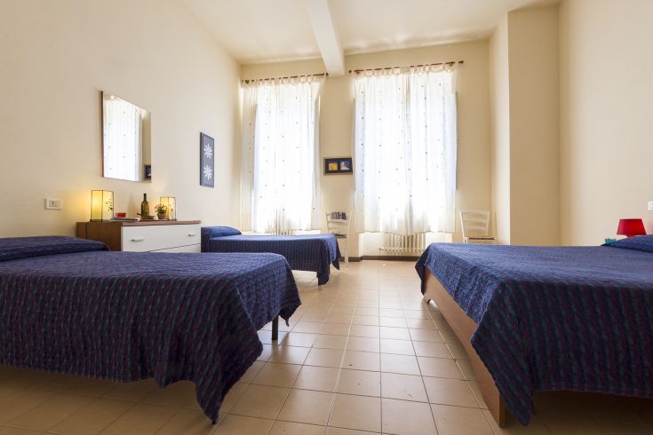 Gemütliches Zimmer mit Einzelbetten, natürlichem Licht und Blick auf den See.