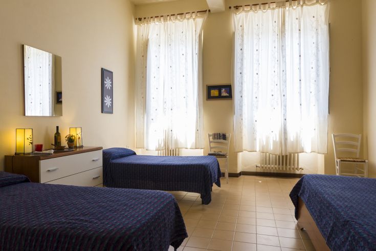 Helle Zimmer mit Einzelbetten und schlichter Einrichtung, dank der großen Fenster, die Tageslicht hereinlassen.