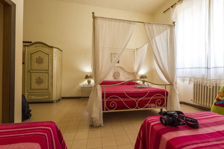 Gemütliches Zimmer mit Himmelbetten und schlichten Möbeln, in einer warmen und komfortablen Umgebung.