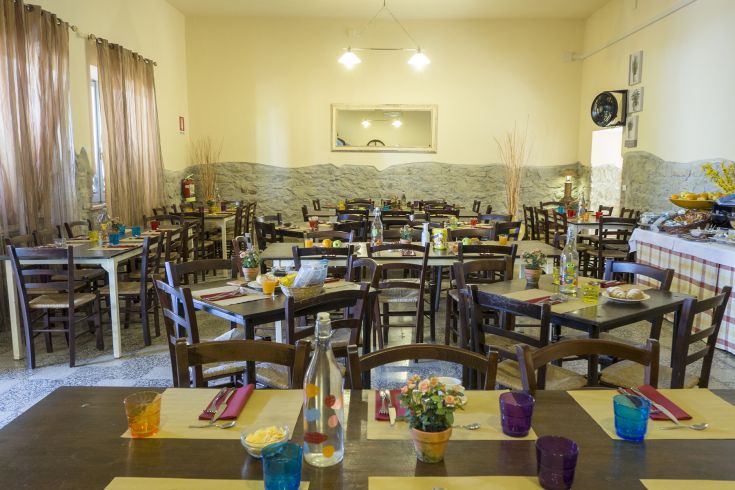 Gemütliche und informelle Atmosphäre, mit ordentlich angeordneten Tischen und lebhaften Farben, ideal für gesellige Momente.