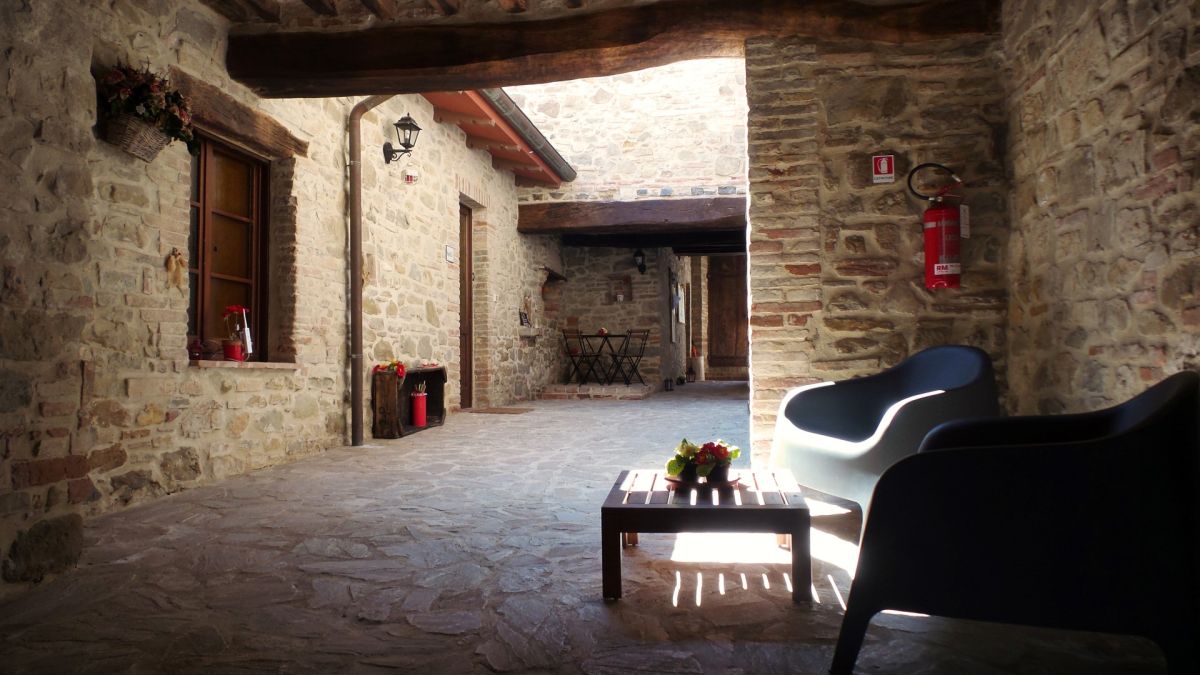A serene scene in a rustic Umbrian farmhouse courtyard, featuring simple furnishings and natural materials.