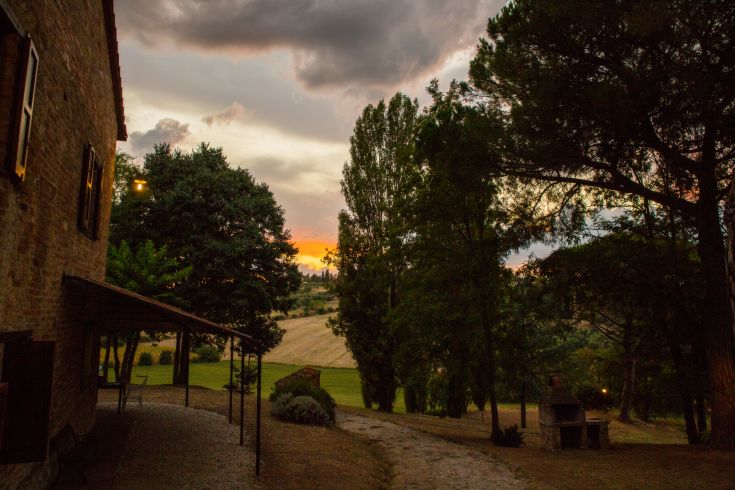 An 18th-century building nestled in the countryside, surrounded by olive trees and vineyards.