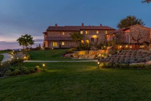 A villa in Umbria surrounded by a simple garden, illuminated by soft lights.