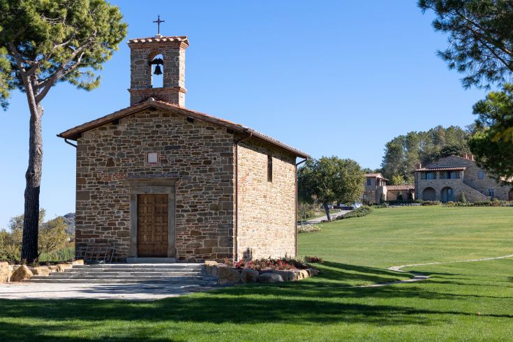 A stone religious building nestled among trees and greenery, expressing harmony with nature.
