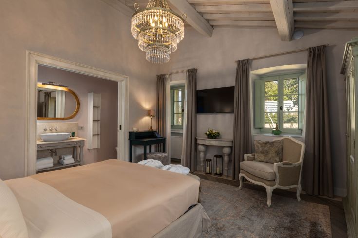 Cozy bedroom with bright details overlooking a natural landscape.