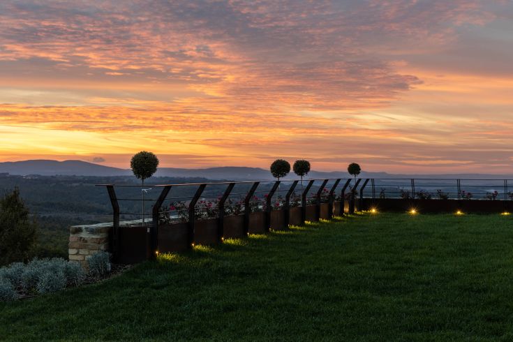 A sunset on a terrace surrounded by greenery, creating a peaceful atmosphere.