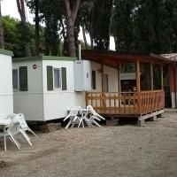 Un camping entouré de verdure, avec plusieurs mobil-homes et un restaurant disponible pour les invités.