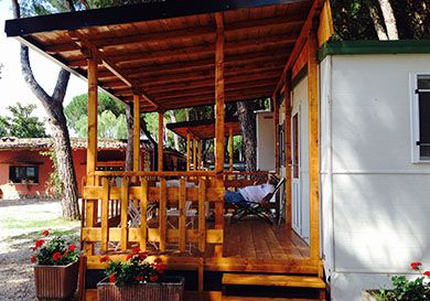 Structure en bois avec vérandas, entourée de verdure, idéale pour des moments de détente.