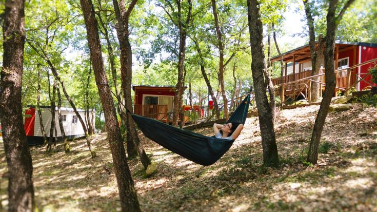 Relax in a hammock at Camping Village Cerquestra, surrounded by nature and next to Lake Trasimeno.