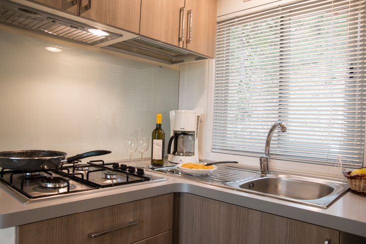 Functional kitchen with a cooking area and washing space. Bright and comfortable environment.