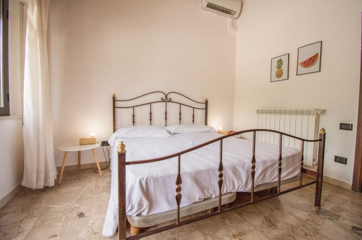 Camera di un hotel semplice, con un letto matrimoniale e decorazioni sobrie.