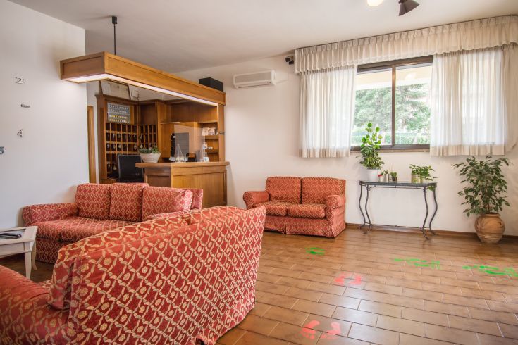 Spazio accogliente per la ricezione degli ospiti dell'hotel, con divani e panorama sul giardino.