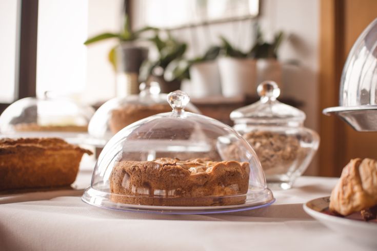 Una selezione di dolci esposti sotto cupole di vetro in un ambiente piacevole e curato.