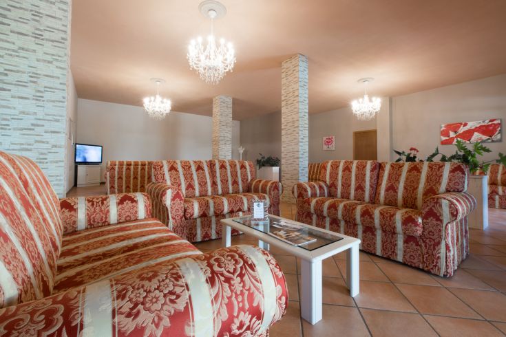 Une salle de séjour confortable avec des canapés rayés et des lustres suspendus.