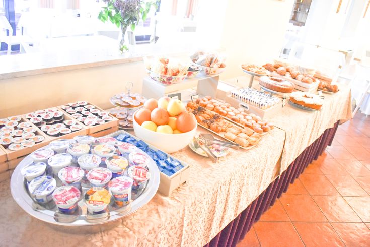 Un buffet varié avec des douceurs, des fruits frais et du yaourt, dans un cadre confortable.