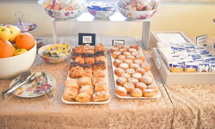 Buffet de petit-déjeuner reconnaissable avec des pâtisseries, des fruits frais et des options simples pour bien commencer la journée.