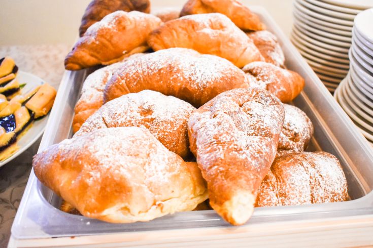 Croissants frais et dorés, légèrement saupoudrés de sucre glace, parfaits pour un petit-déjeuner simple.