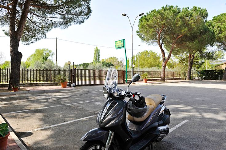 Un stationnement paisible près du lac Trasimeno, avec une moto prête à partir.