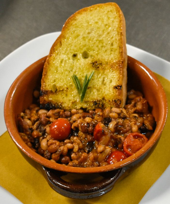 Un plat délicieux à base de légumineuses, de tomates cerises fraîches et de tranches de pain grillé.