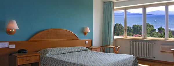 Chambre confortable avec vue sur le lac Trasimeno, décor simple et accueillant.