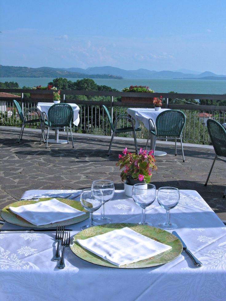 Un restaurant au bord du lac avec une terrasse accueillante pour les clients.