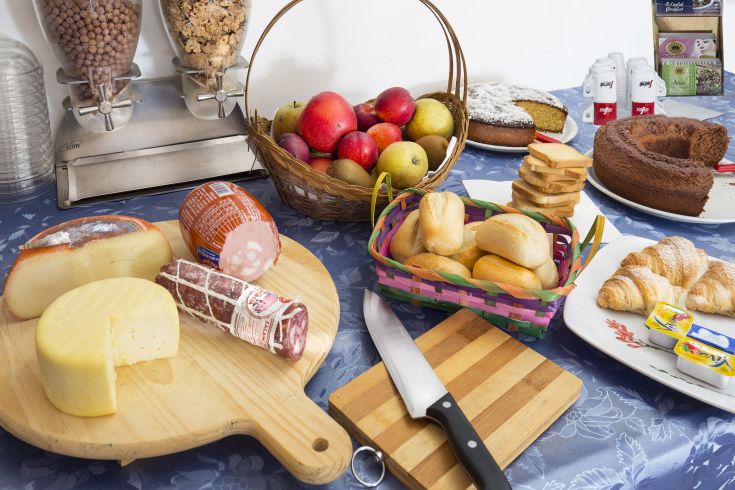 A varied buffet with cheeses, cold cuts, fresh fruits, and assorted desserts. Perfect to start the day with flavor.