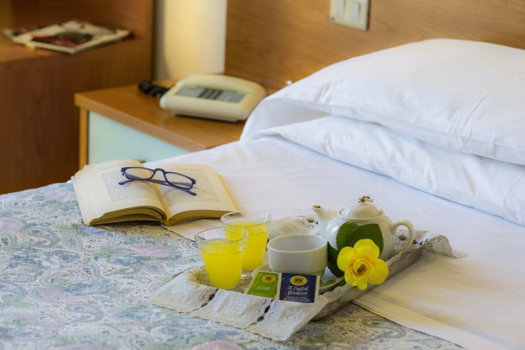 A simple breakfast served in the room, featuring a fresh drink and some books on the table.