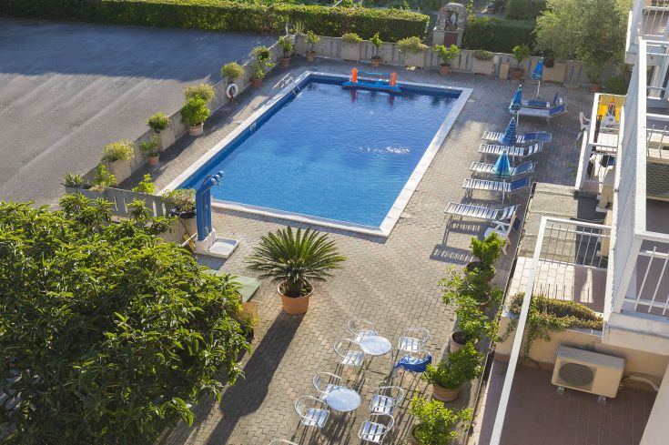 Swimming pool and relaxation area at Hotel La Darsena, nestled among the hills near Lake Trasimeno.