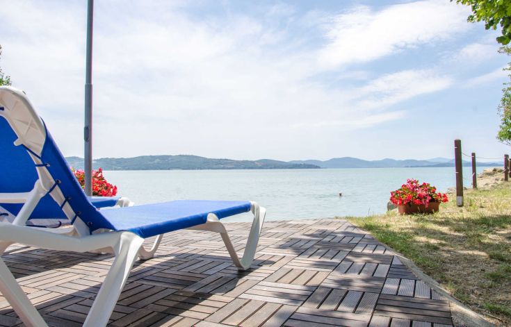 A relaxing moment by the shores of Lake Trasimeno, with comfortable sunbeds.