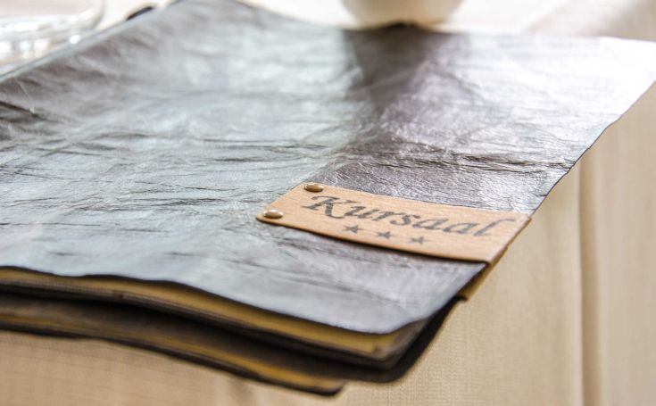 Well-presented menu of Hotel Kursaal, featuring wooden details that evoke a sleek design.
